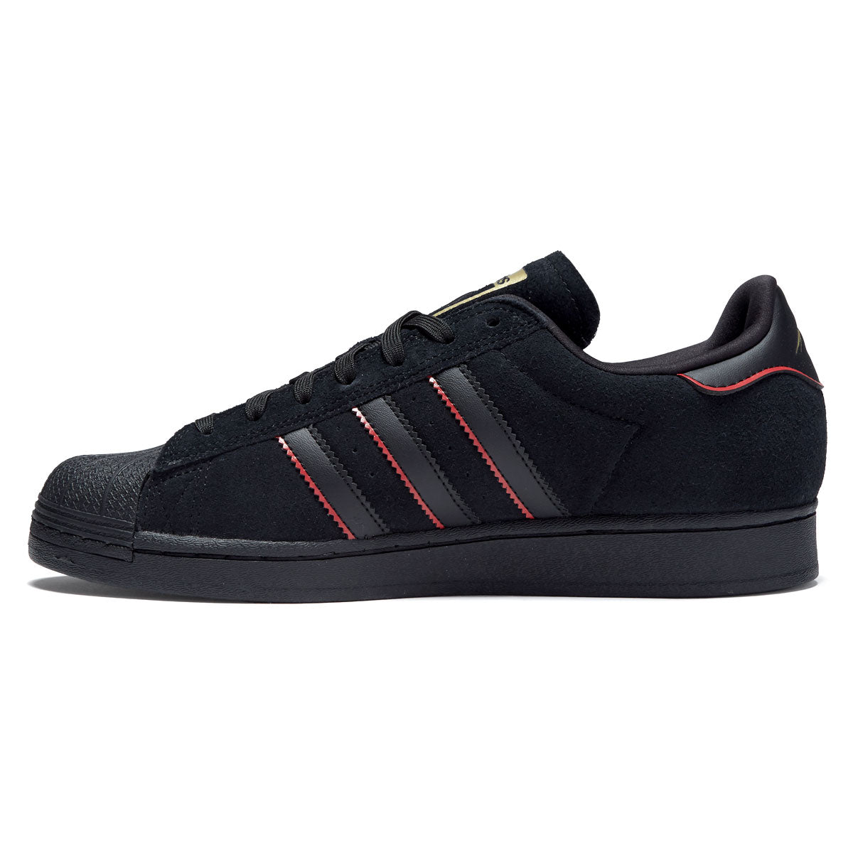 black adidas with gold stripes